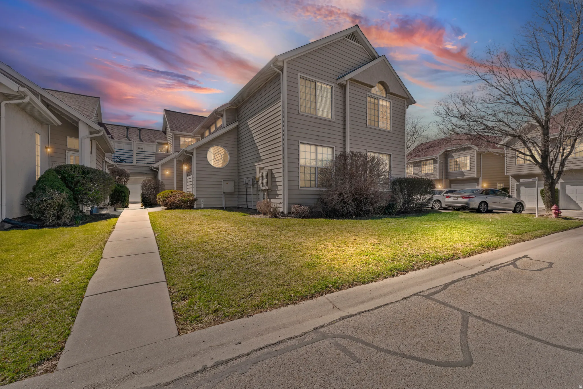Property exterior at dusk featuring a lawn