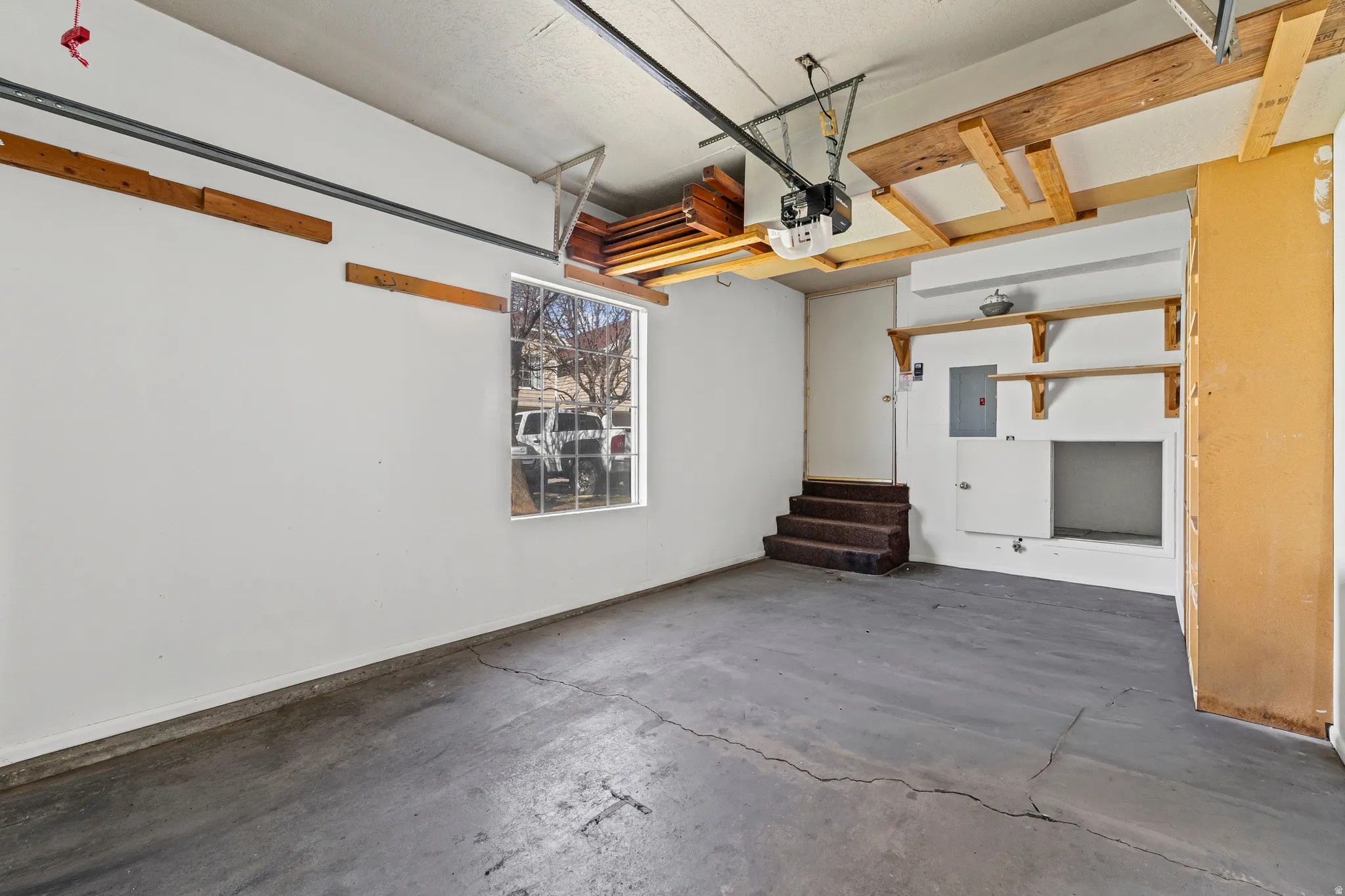 Garage with electric panel and a garage door opener