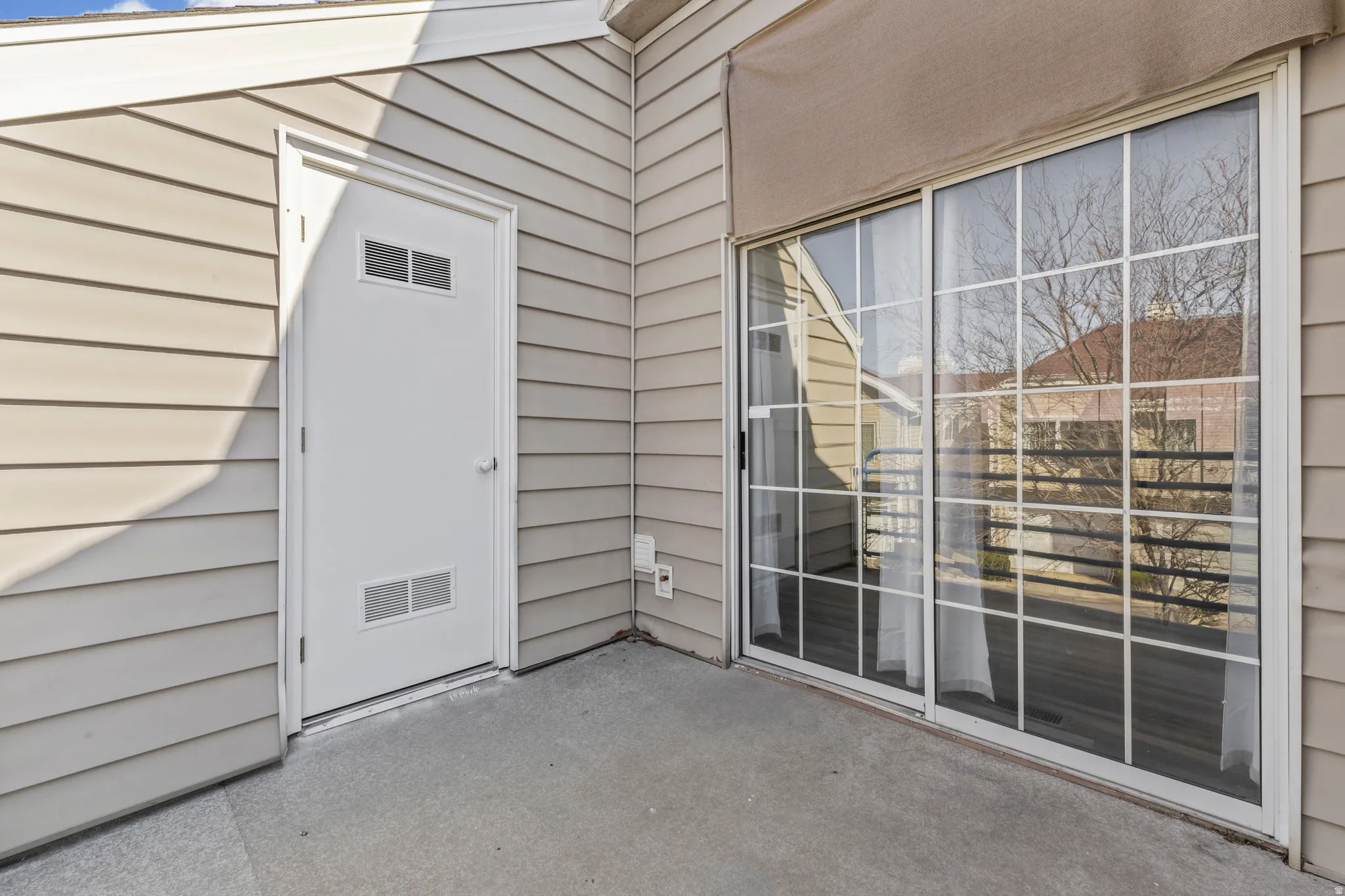 View of exterior entry with a patio area