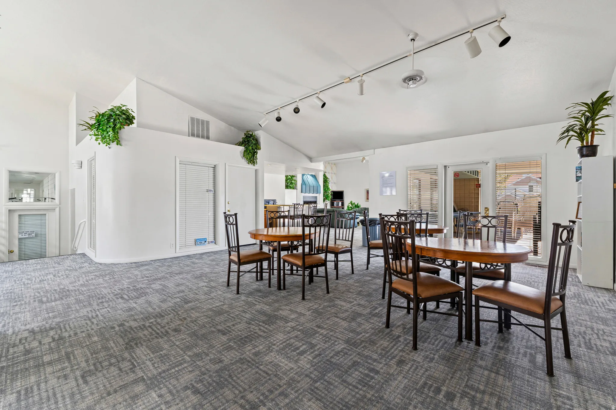 Carpeted dining room featuring rail lighting and vaulted ceiling