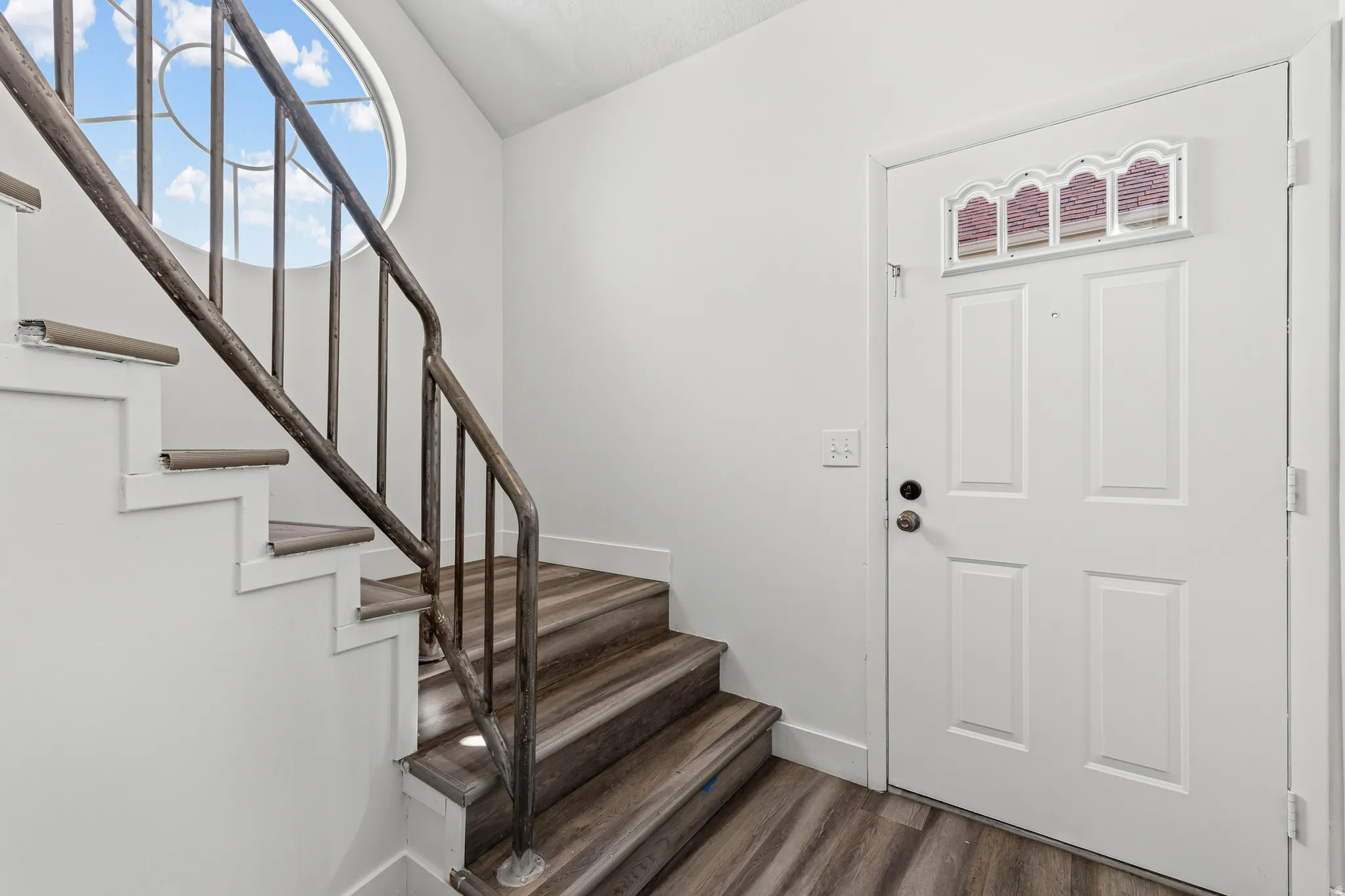 Foyer featuring dark wood-type flooring and lofted ceiling