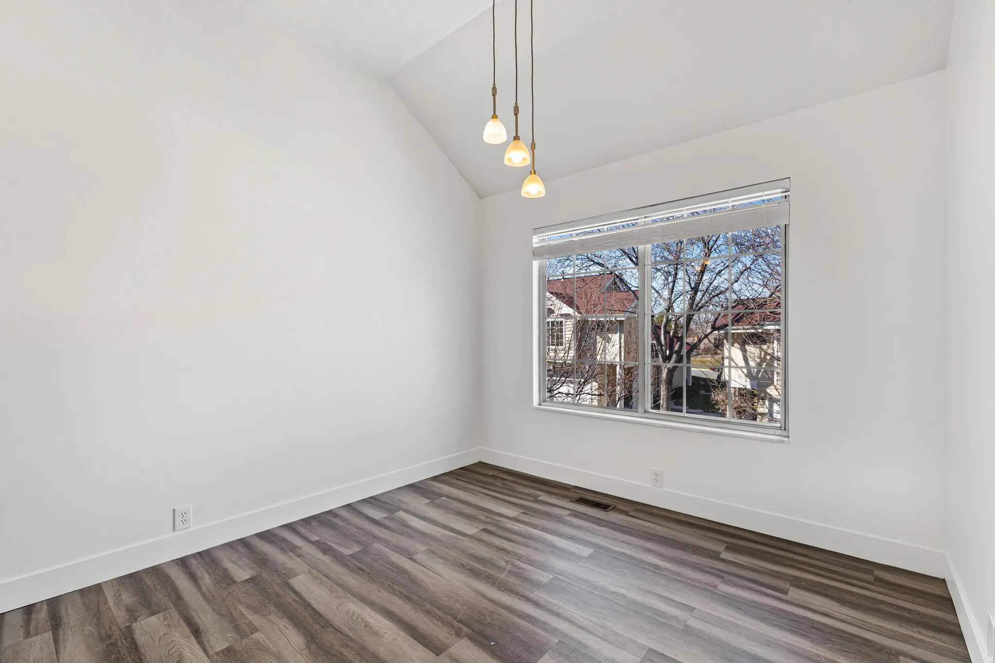 Unfurnished dining area featuring lofted ceiling and dark wood-style flooring