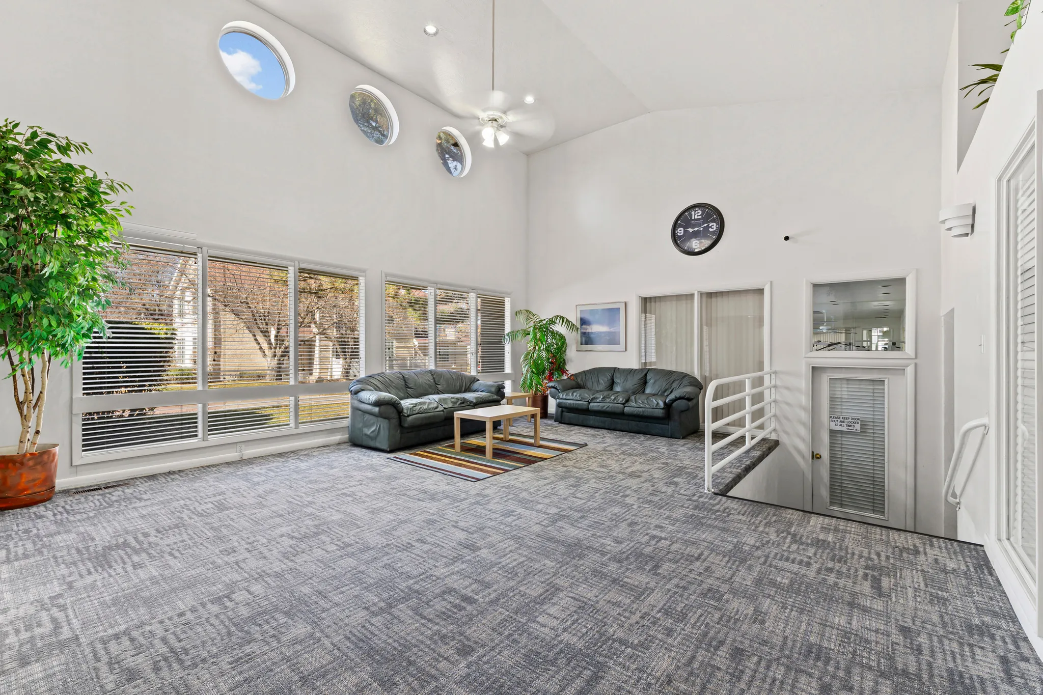 Carpeted living area featuring lofted ceiling and ceiling fan