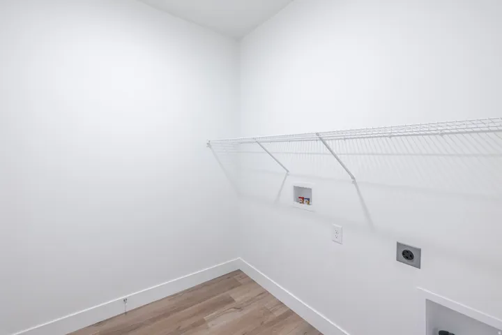 Utility area featuring wood-finish flooring and a wire shelving unit