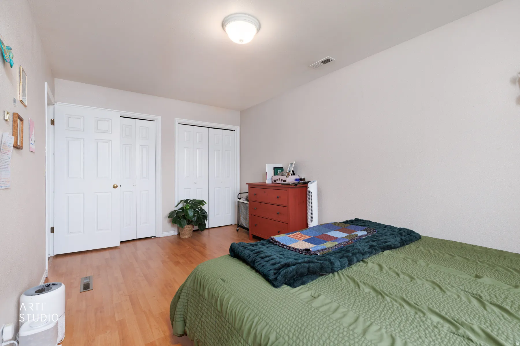 Bedroom featuring multiple closets and wood finished floors