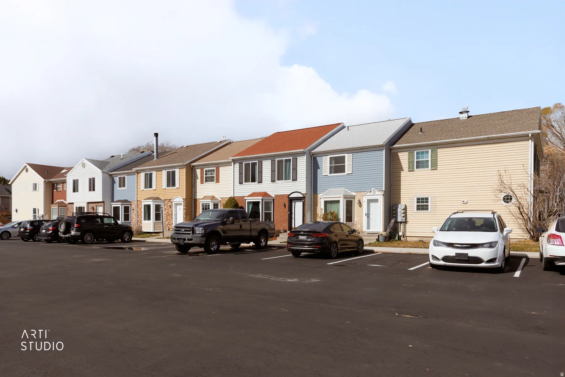 View of building exterior with a residential view and uncovered parking
