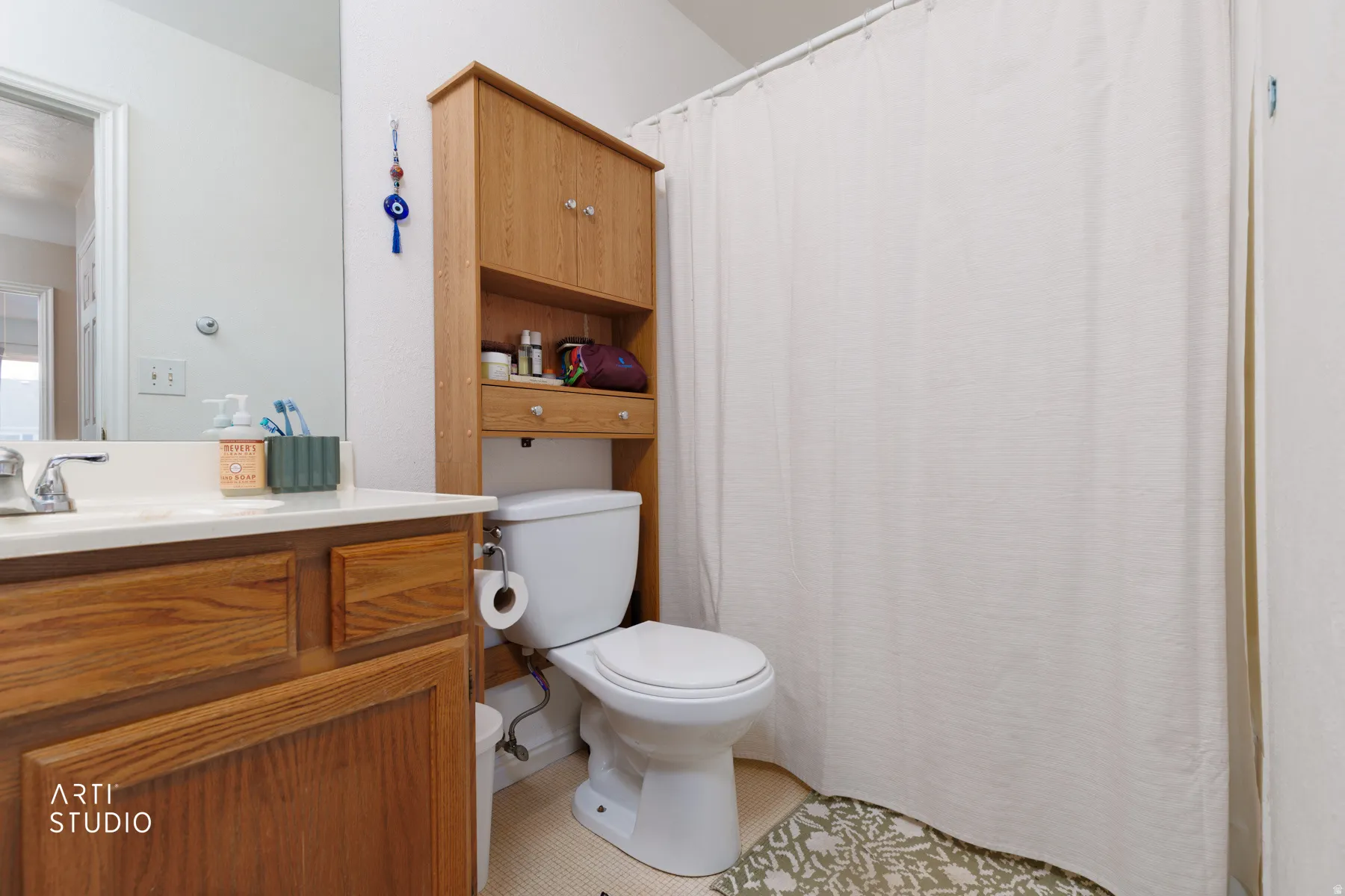 Bathroom with vanity, a shower with curtain, and light tile patterned floors