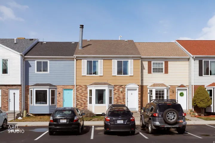 Colonial home featuring brick siding, a shingled roof, and a residential view