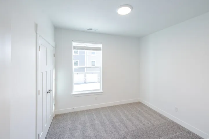 Recessed ceiling light, white walls, and light gray carpet