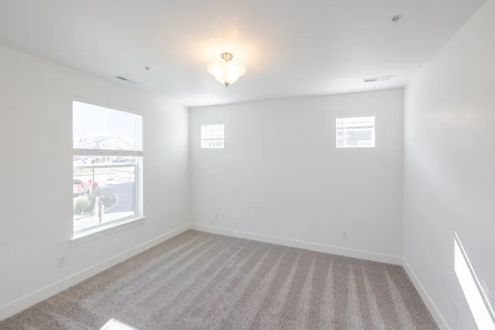 Plush carpet flooring, white painted walls, and a semi-flush mount ceiling fixture