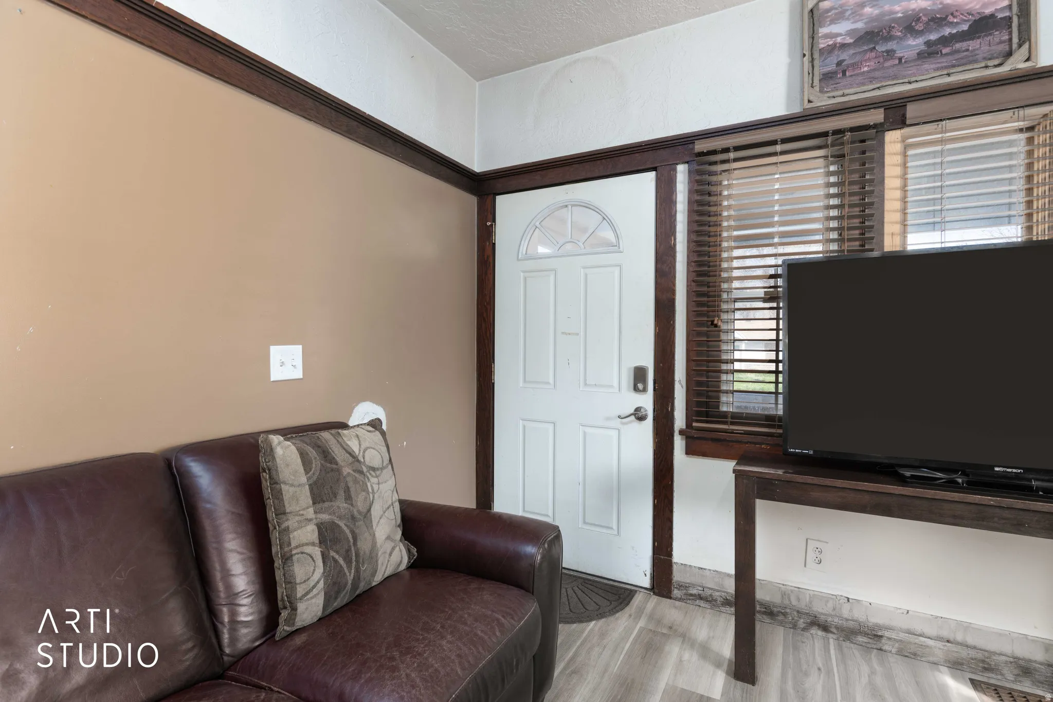 Living room with a textured ceiling and light wood-style flooring