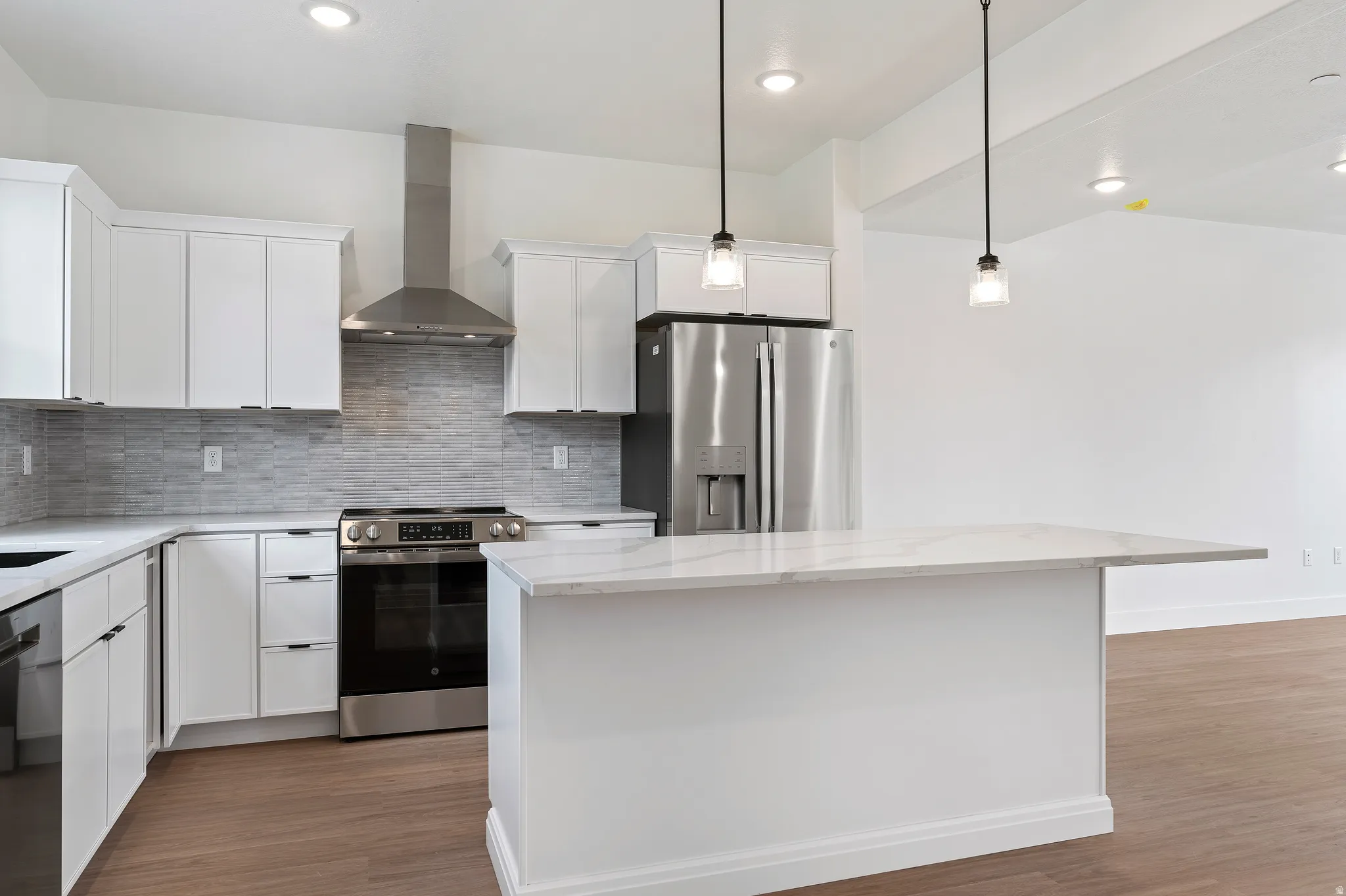 Kitchen with stainless steel appliances, white cabinets, a center island, and dark wood finished floors