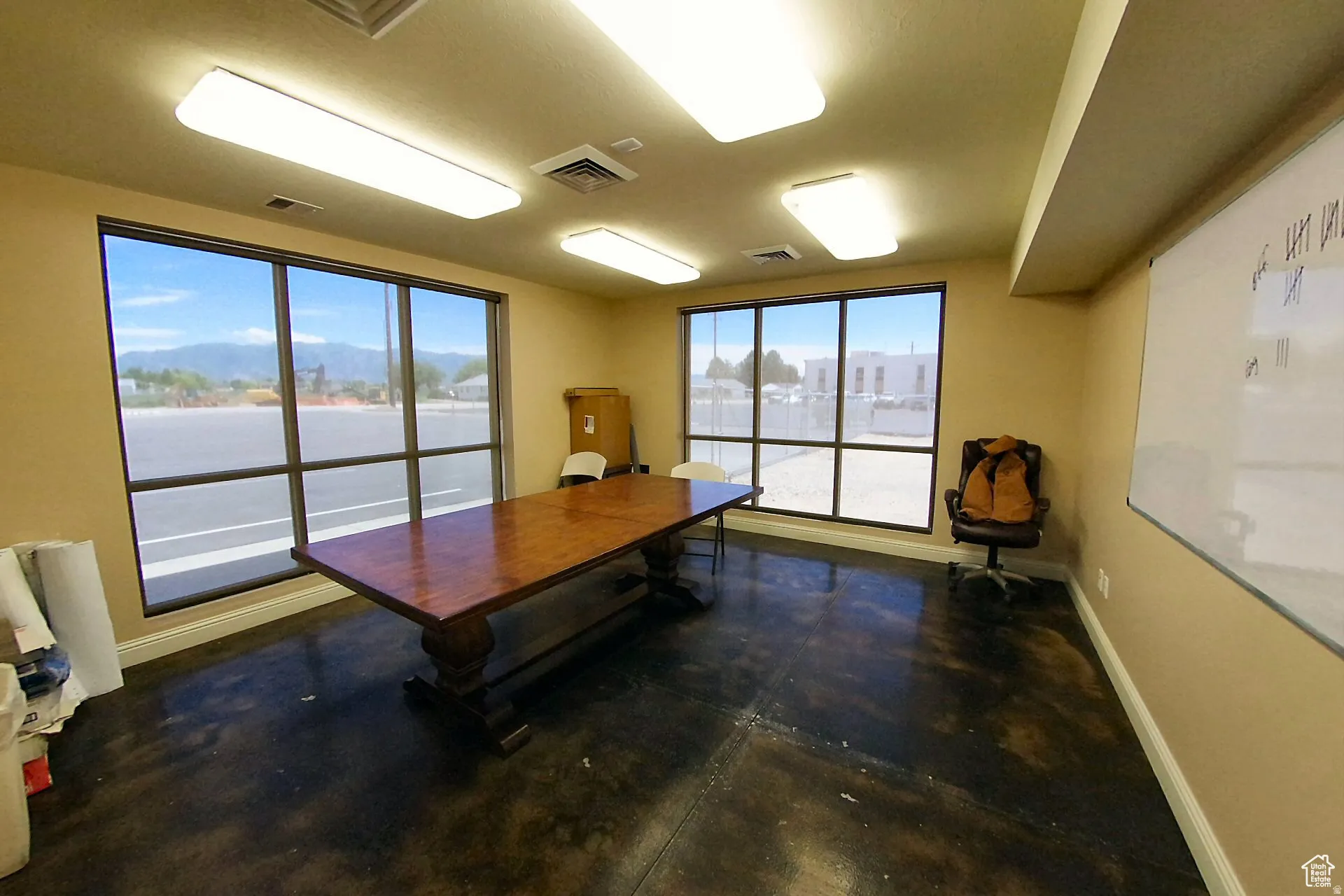 Home office with baseboards and finished concrete floors