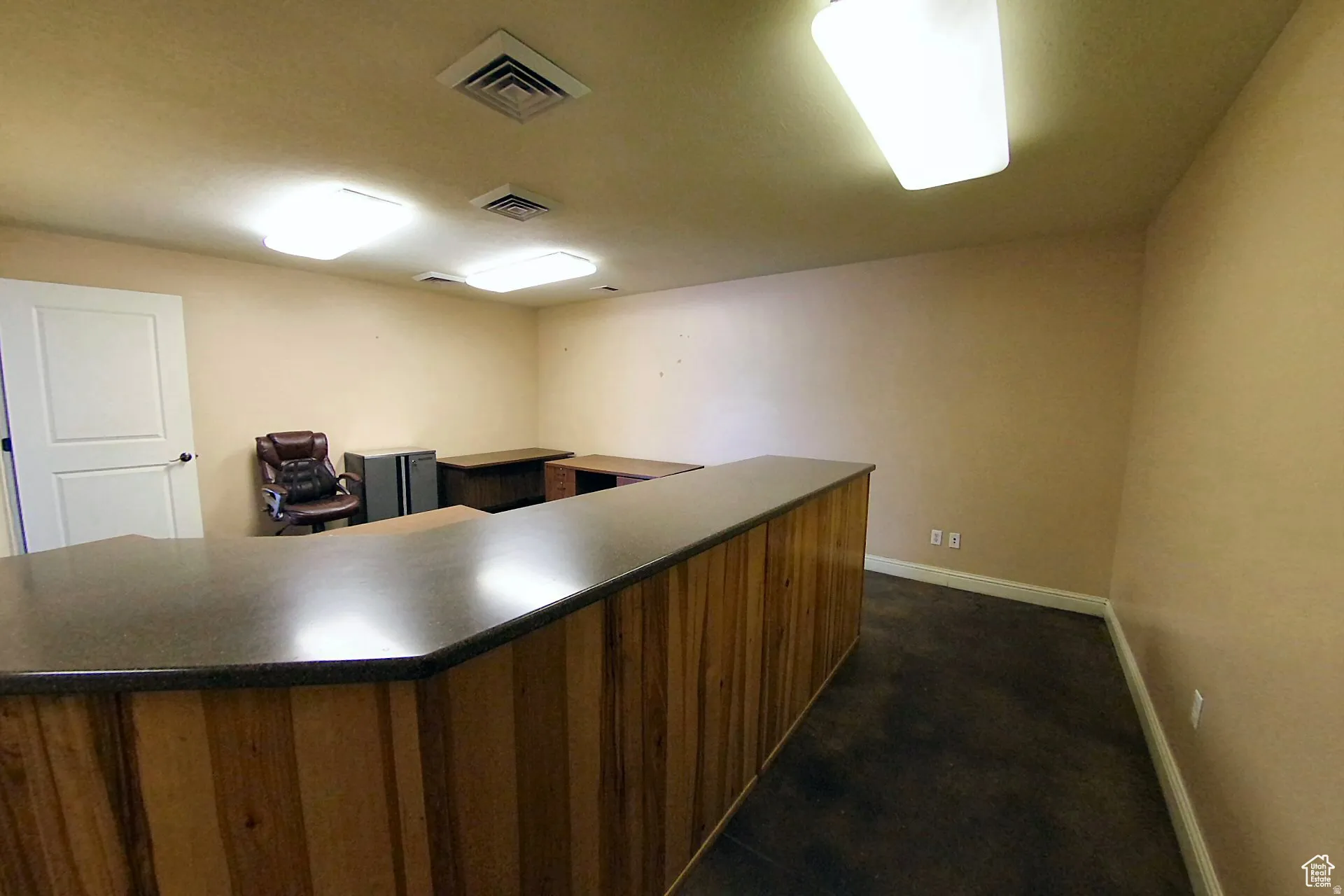 Office area with dark carpet and a bar