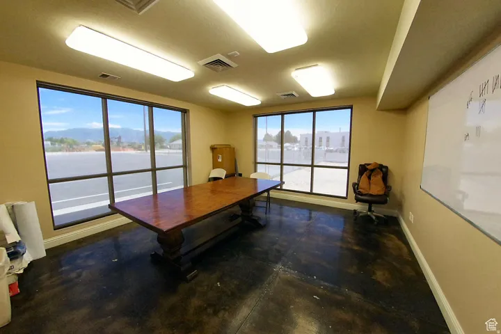 Home office with baseboards and finished concrete floors