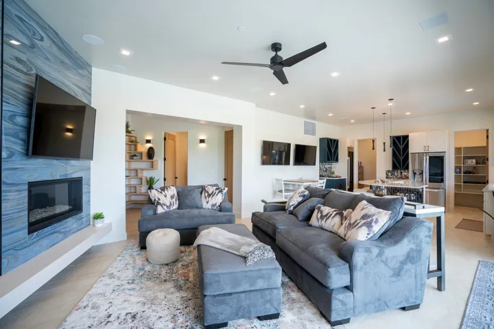 Living area with a ceiling fan, a high end fireplace, recessed lighting, and built in shelves