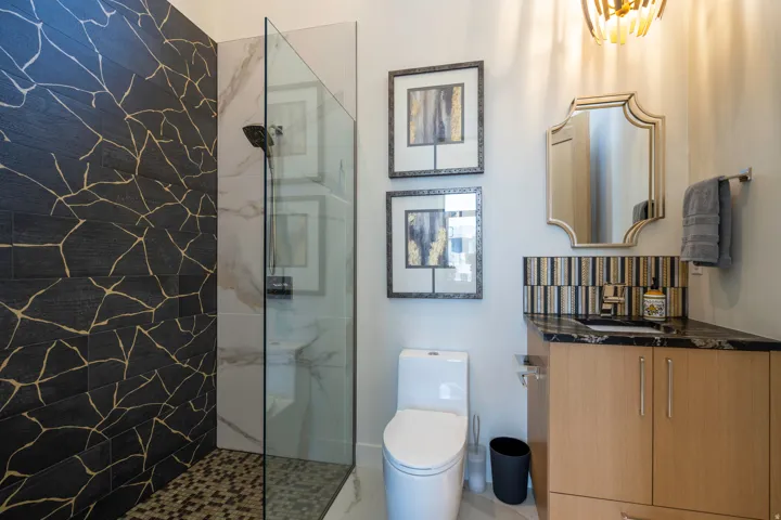 Full bathroom featuring a marble finish shower and vanity