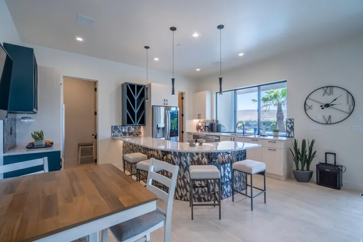 Kitchen with a kitchen bar, light stone countertops, a peninsula, and decorative light fixtures
