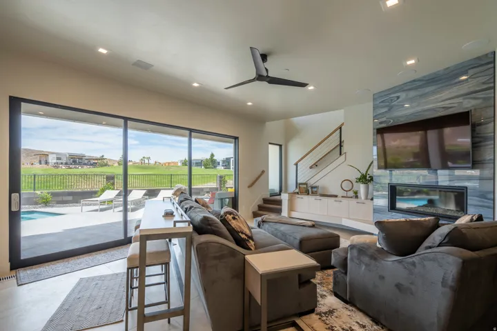 Living room featuring ceiling fan, recessed lighting, and a premium fireplace