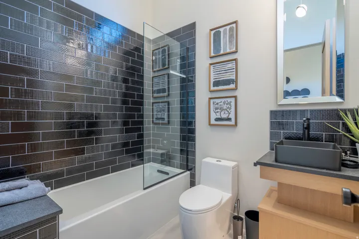 Bathroom featuring vanity, tasteful backsplash, and shower / tub combination