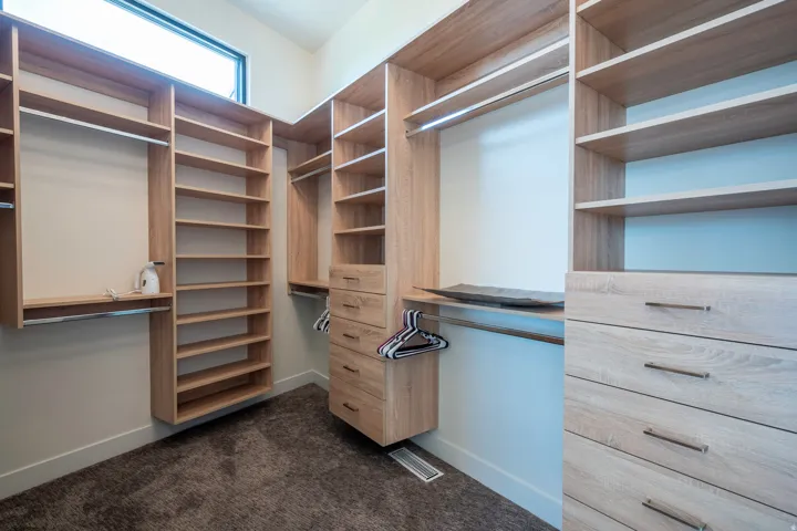 Walk in closet featuring dark carpet
