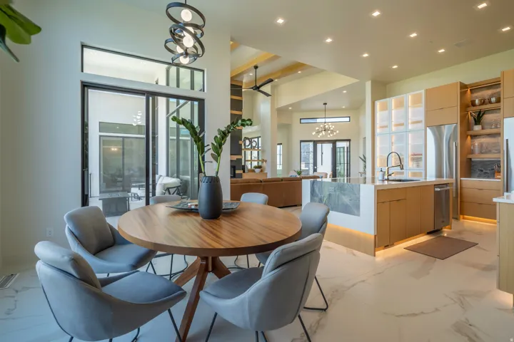 Dining room with suspended lighting and light marble finish floors