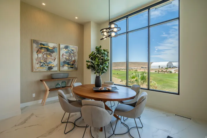 Dining space with suspended lighting and light marble finish floors