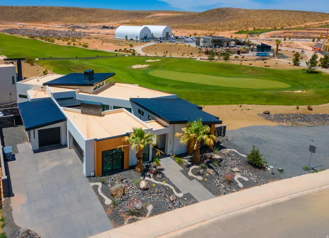 Aerial view of property and surrounding area with a local golf course and a mountain backdrop