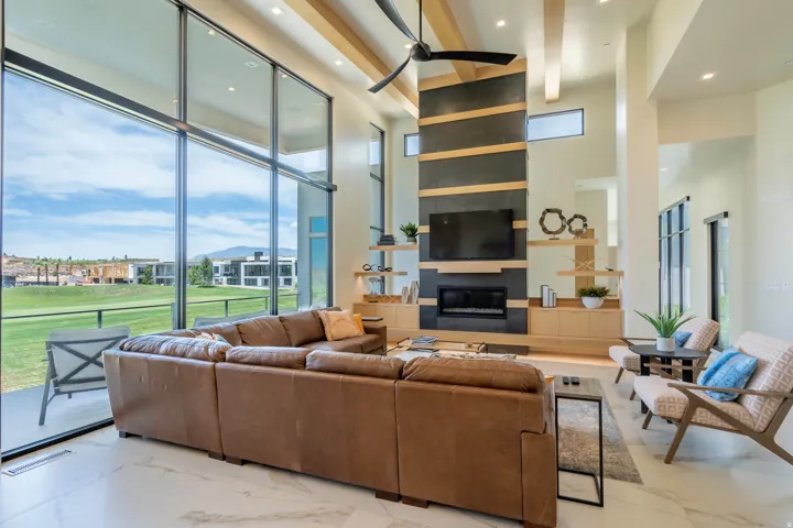 Living room featuring recessed lighting, a large fireplace, light marble finish floors, and a ceiling fan