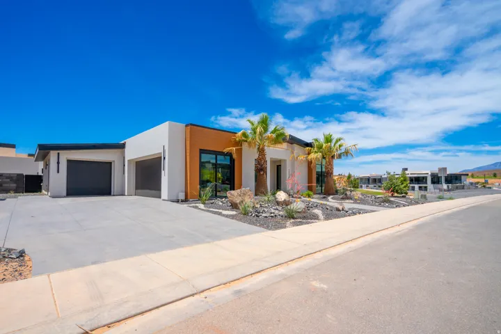 Modern home featuring an attached garage, stucco siding, and driveway