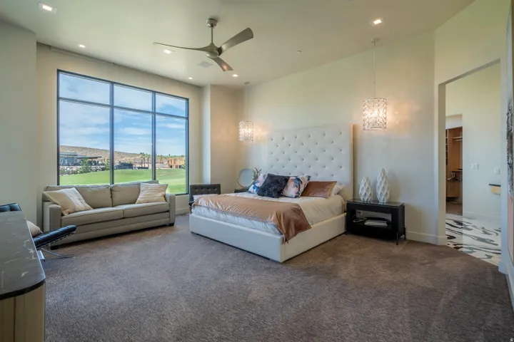 Bedroom with carpet flooring, ceiling fan, and hanging lights