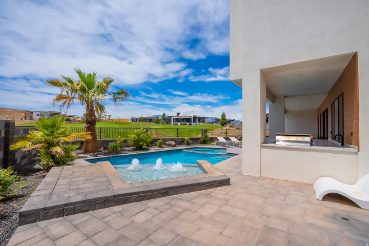 Combined pool / hot tub with a patio, area for grilling, a fenced backyard, and a residential view