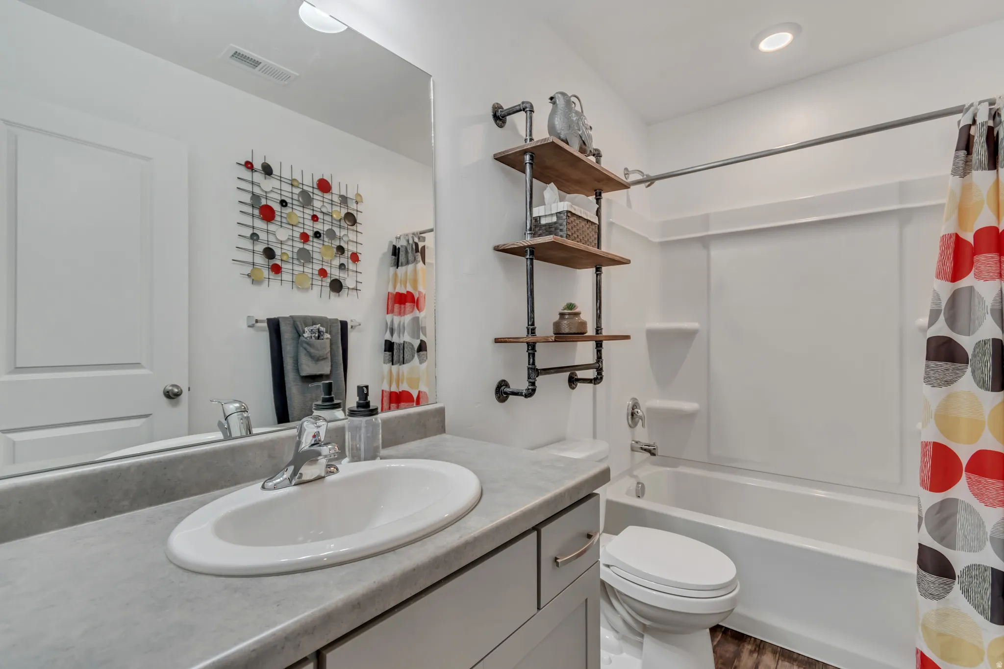 Clean and bright full bathroom with vanity and shower / tub combo.