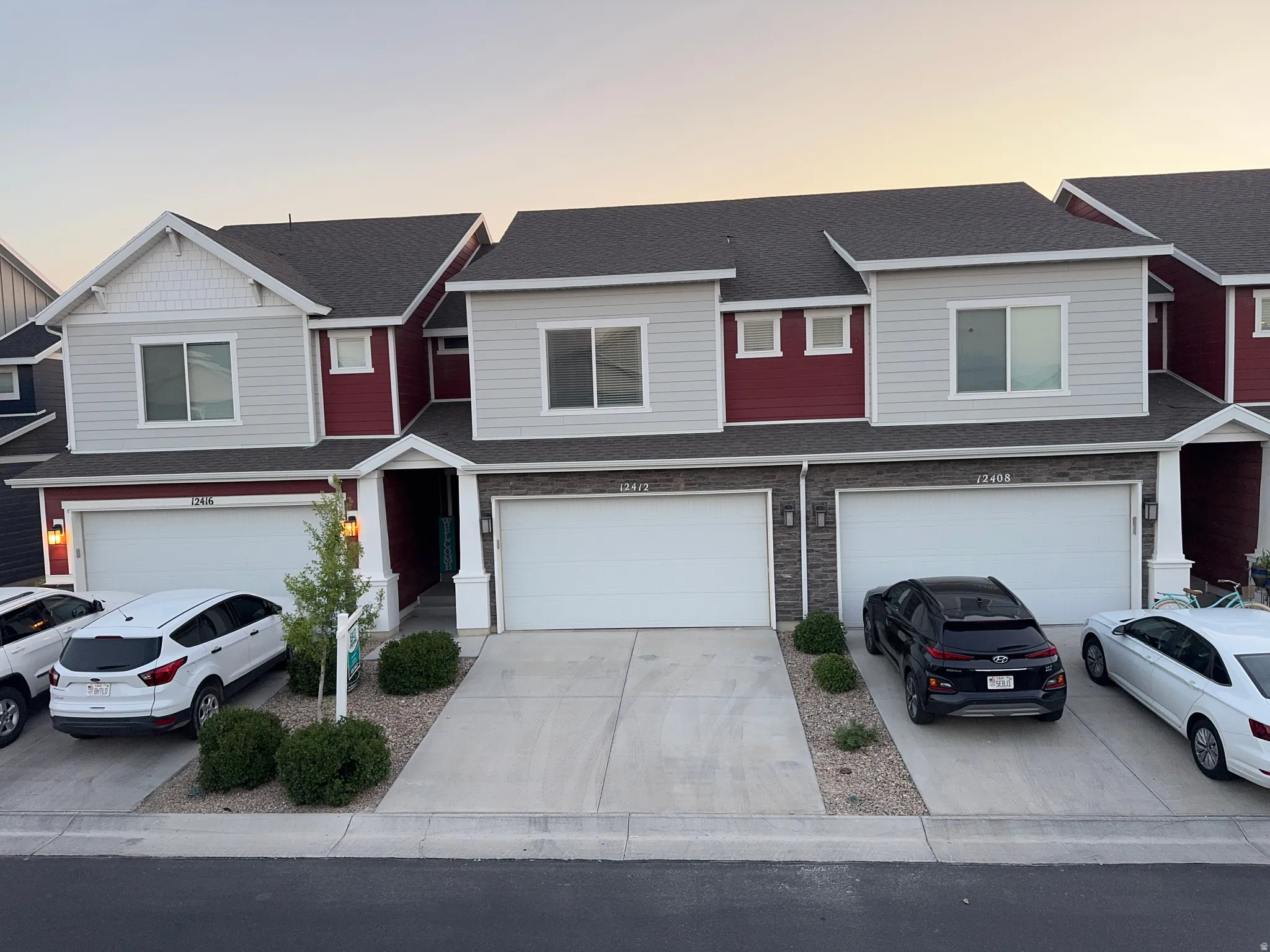 Townhome exterior featuring varied siding materials, attached two-car garages, and covered entryways