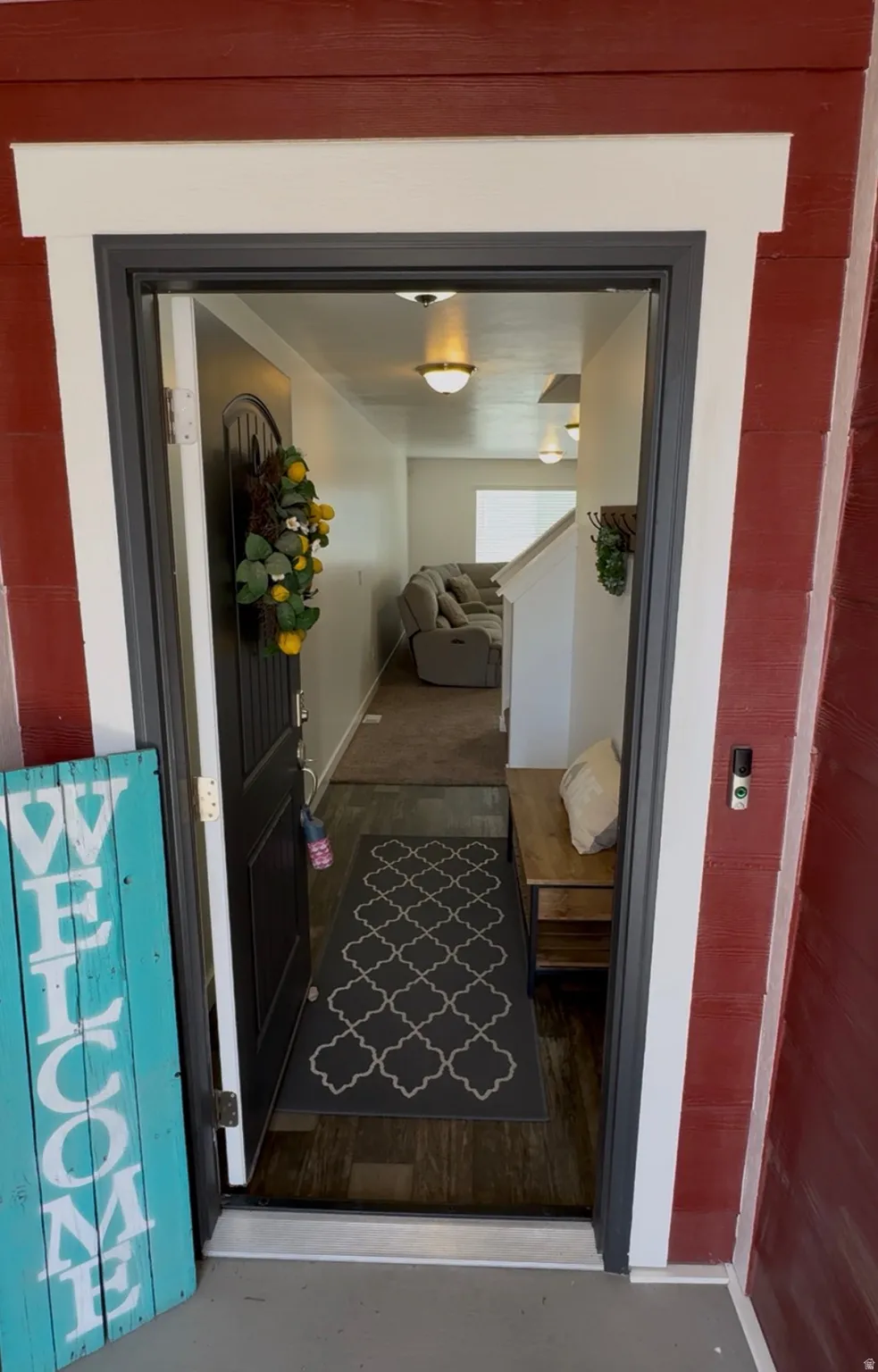 Entrance featuring a dark wood-finish door with decorative glass, leading to an interior with wood-finish flooring