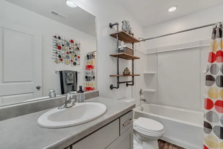 Clean and bright full bathroom with vanity and shower / tub combo.