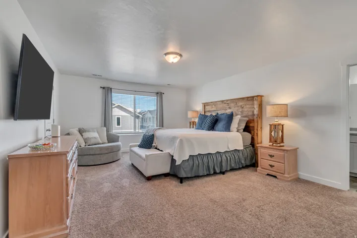 This primary bedroom fits a king size bed, two nightstands, a dresser, an oversized lounge chair,  and a bench at the foot of the bed...and there's still LOTS of extra room to spare!