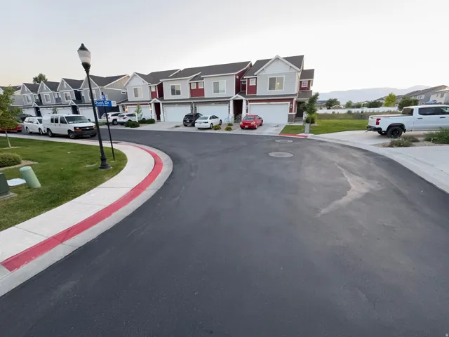 Contemporary townhome featuring a two-story design, gray siding, red accents, and an attached two-car garage