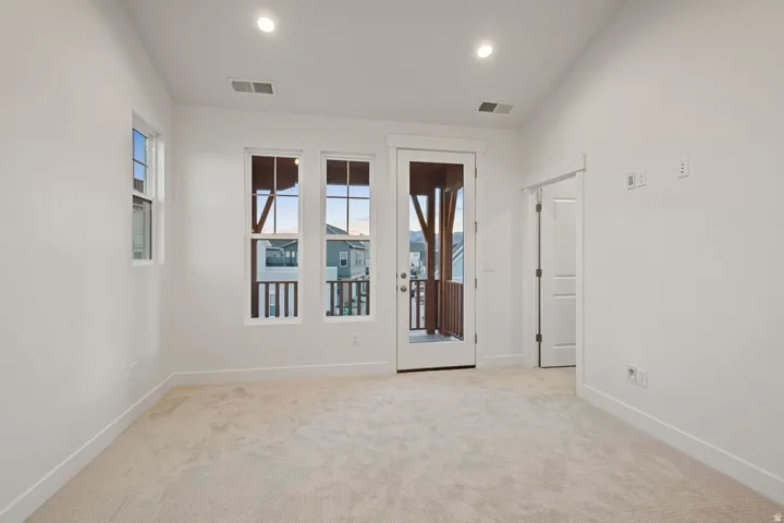 Carpeted empty room with healthy amount of natural light and recessed lighting
