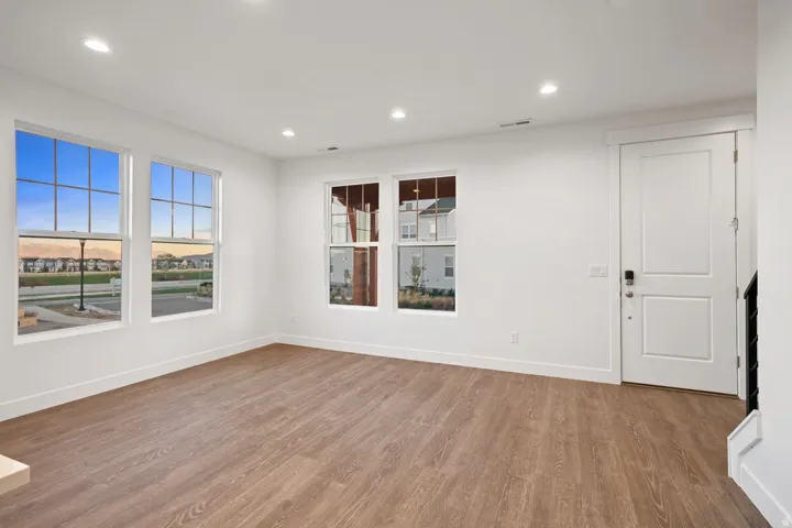 Unfurnished room with wood finished floors and recessed lighting