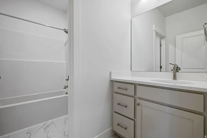 Full bath featuring vanity and washtub / shower combination