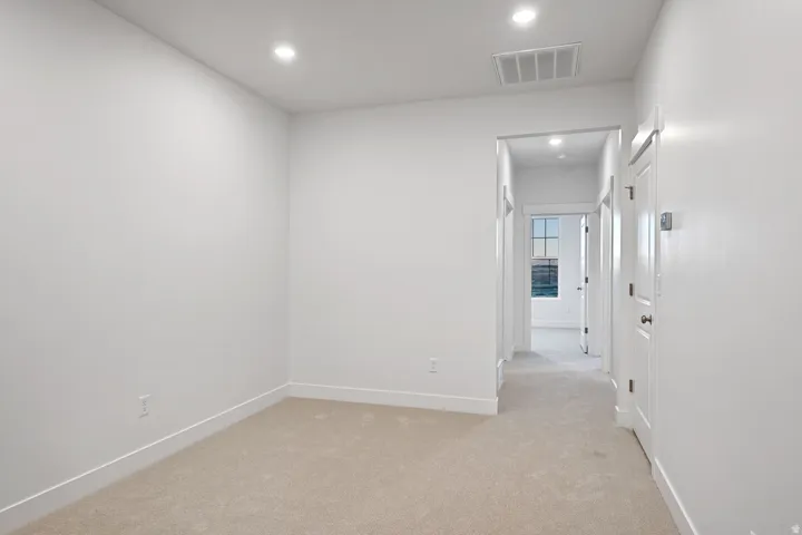 Hall with recessed lighting and light colored carpet