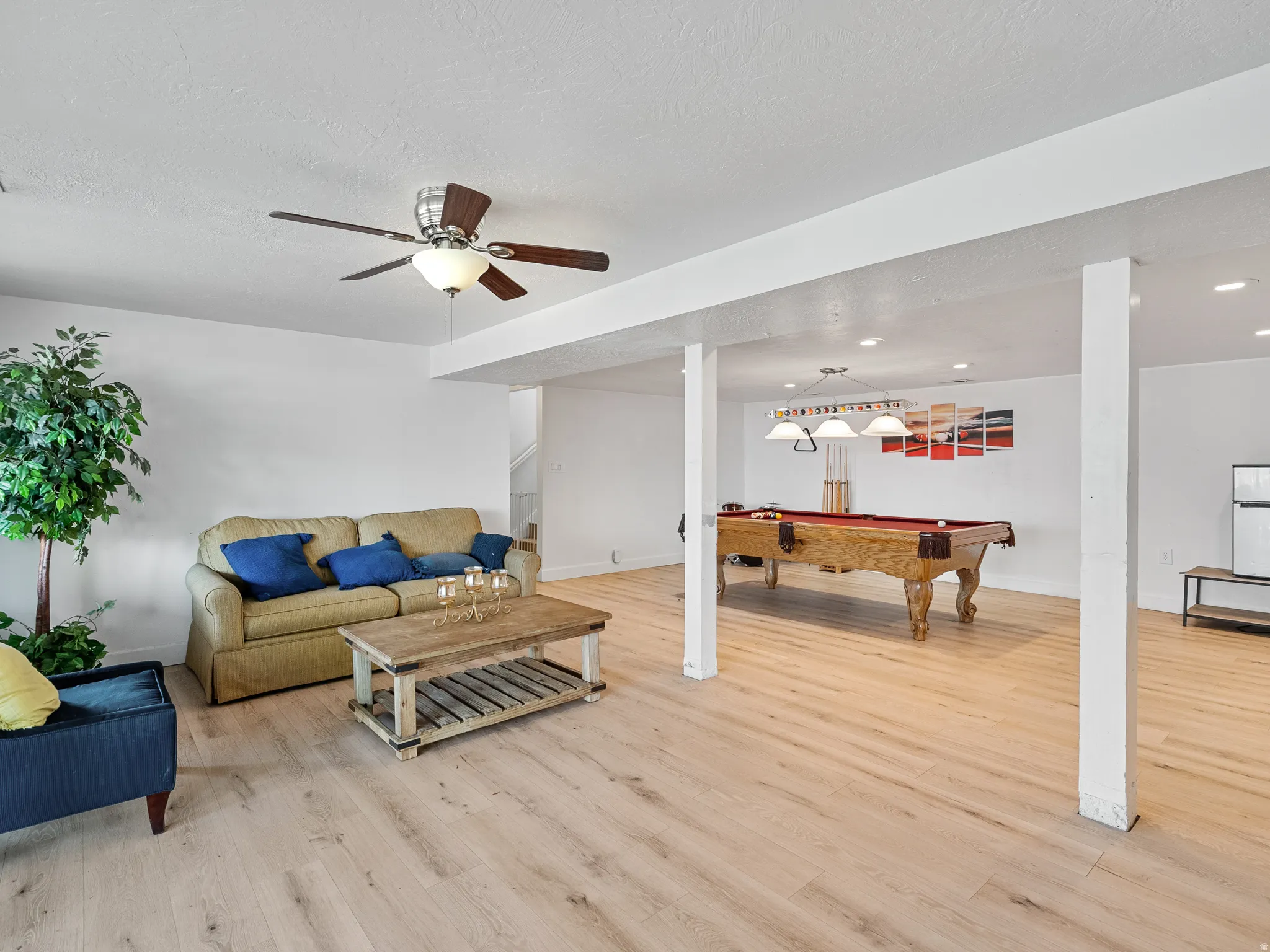 Living area with billiards, light wood-style floors, and a ceiling fan