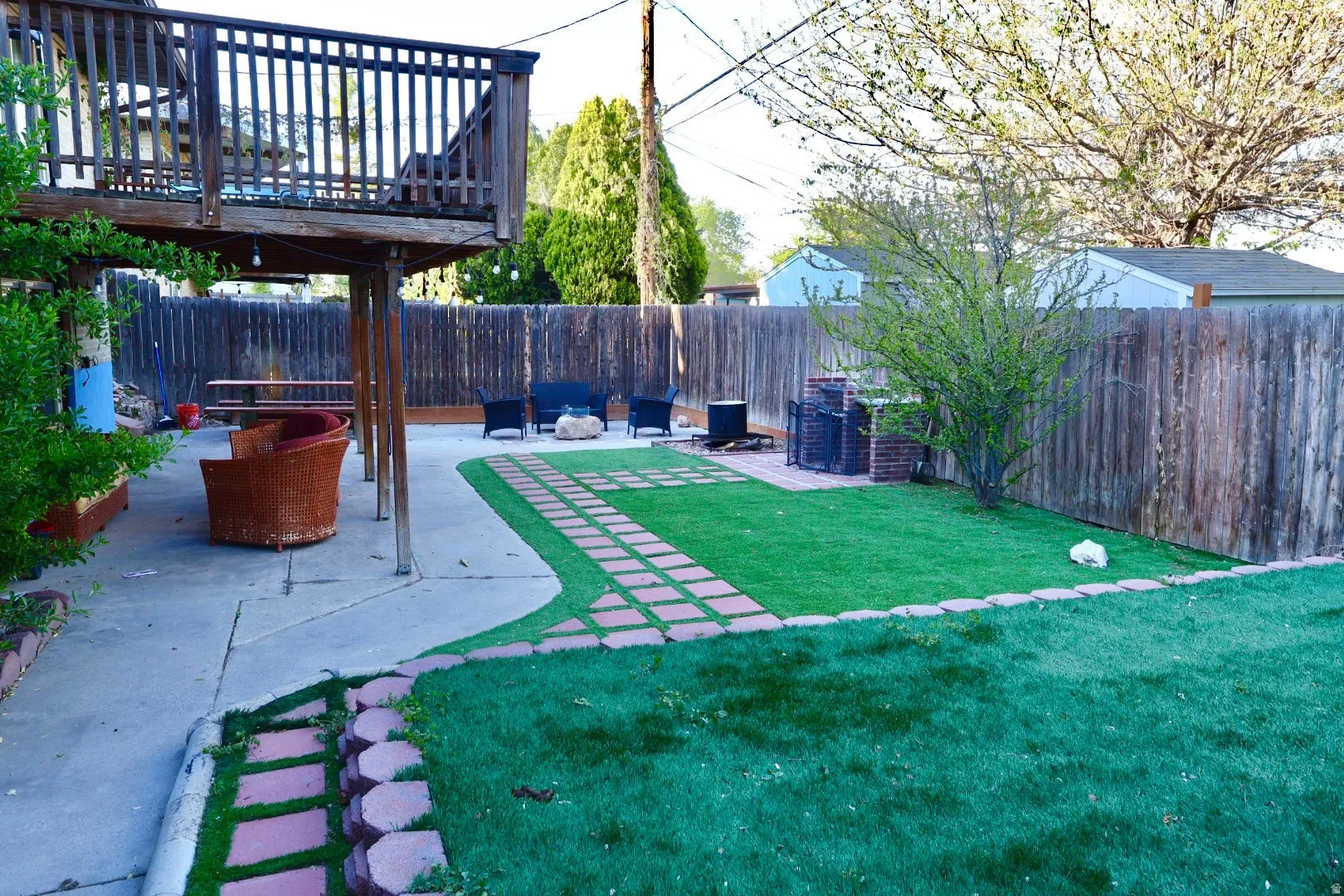 Fenced backyard featuring a wooden deck and a patio area