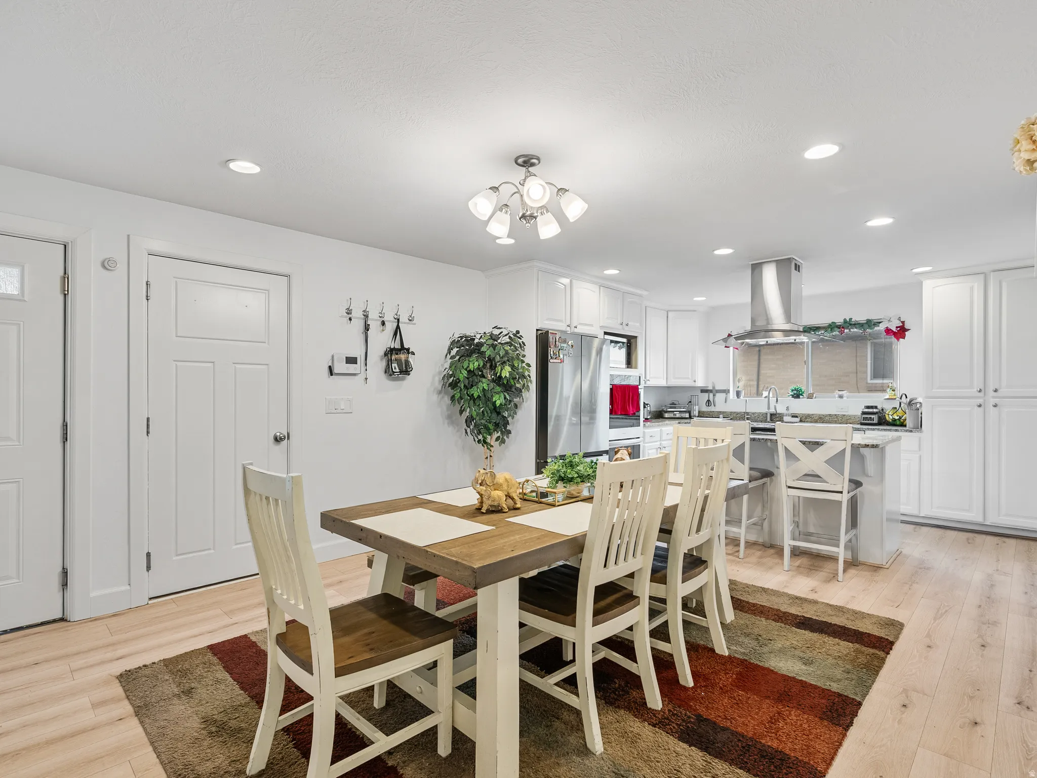 Dining room with light wood finished floors and suspended lighting