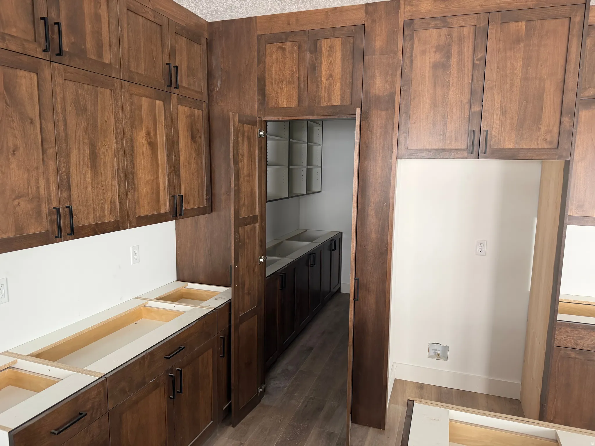 Kitchen featuring dark wood-style floors, dark wood finish cabinetry, and light countertops