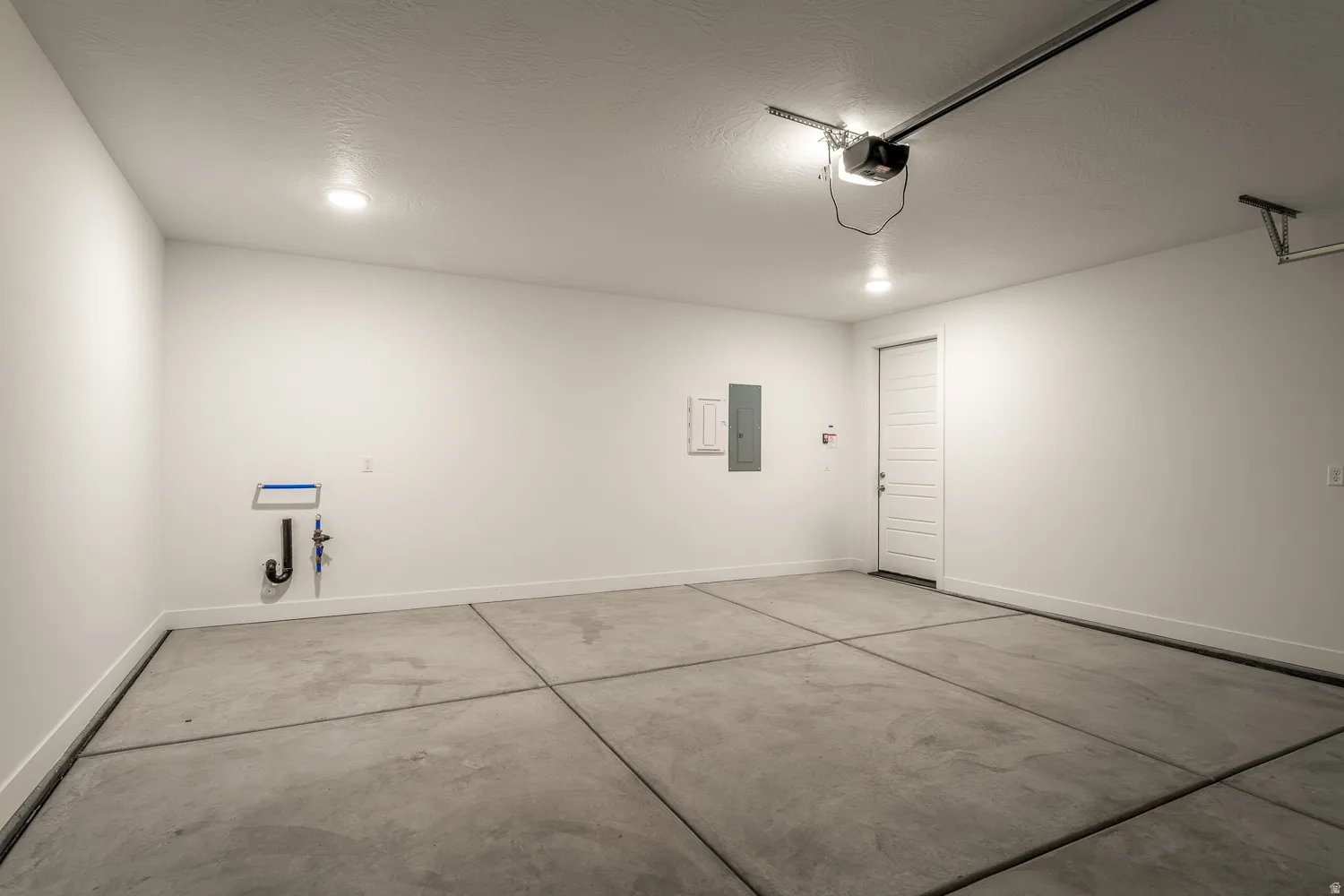 Garage featuring baseboards and electric panel
