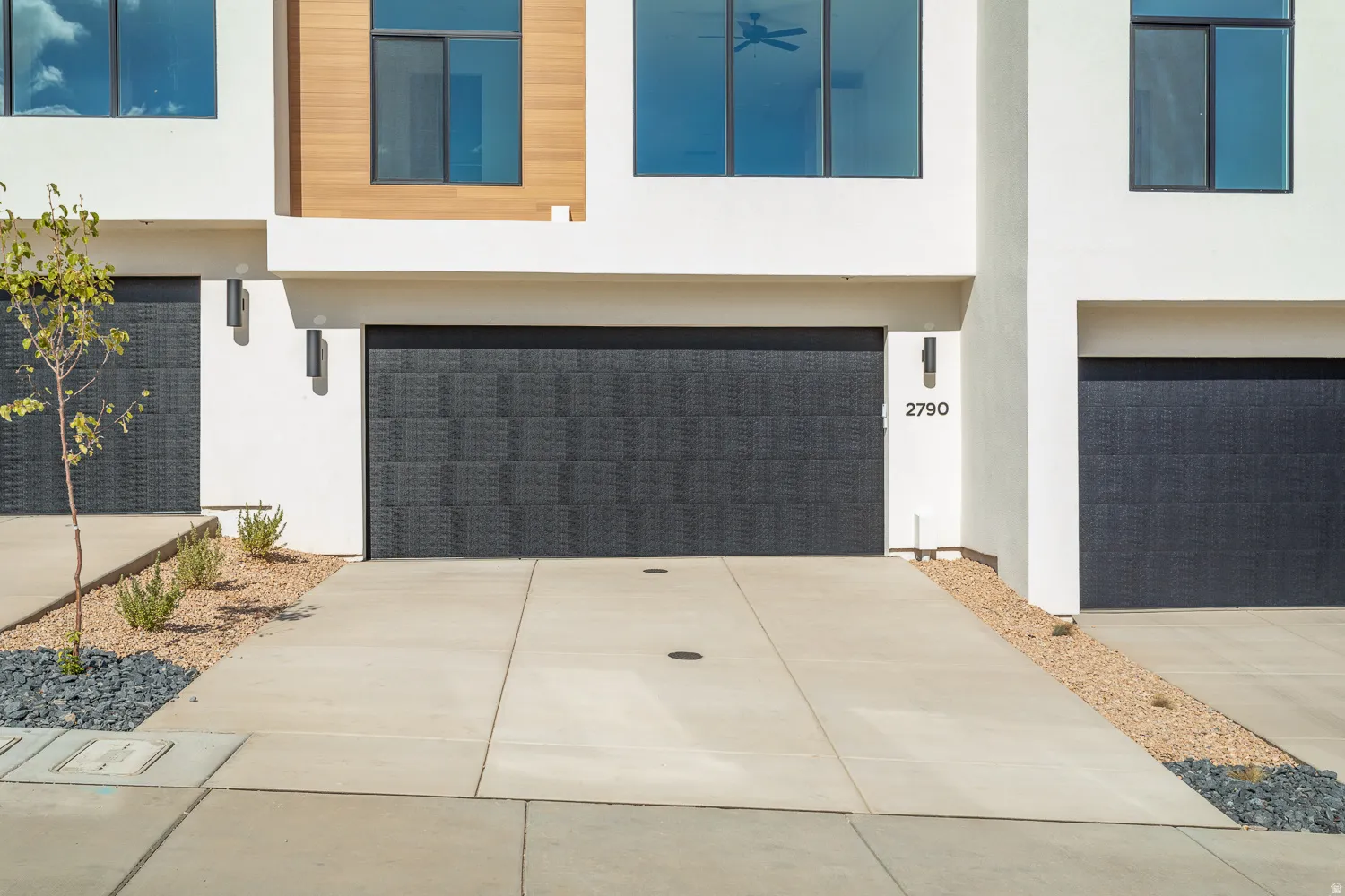 View of front facade with an attached garage, stucco siding, and driveway