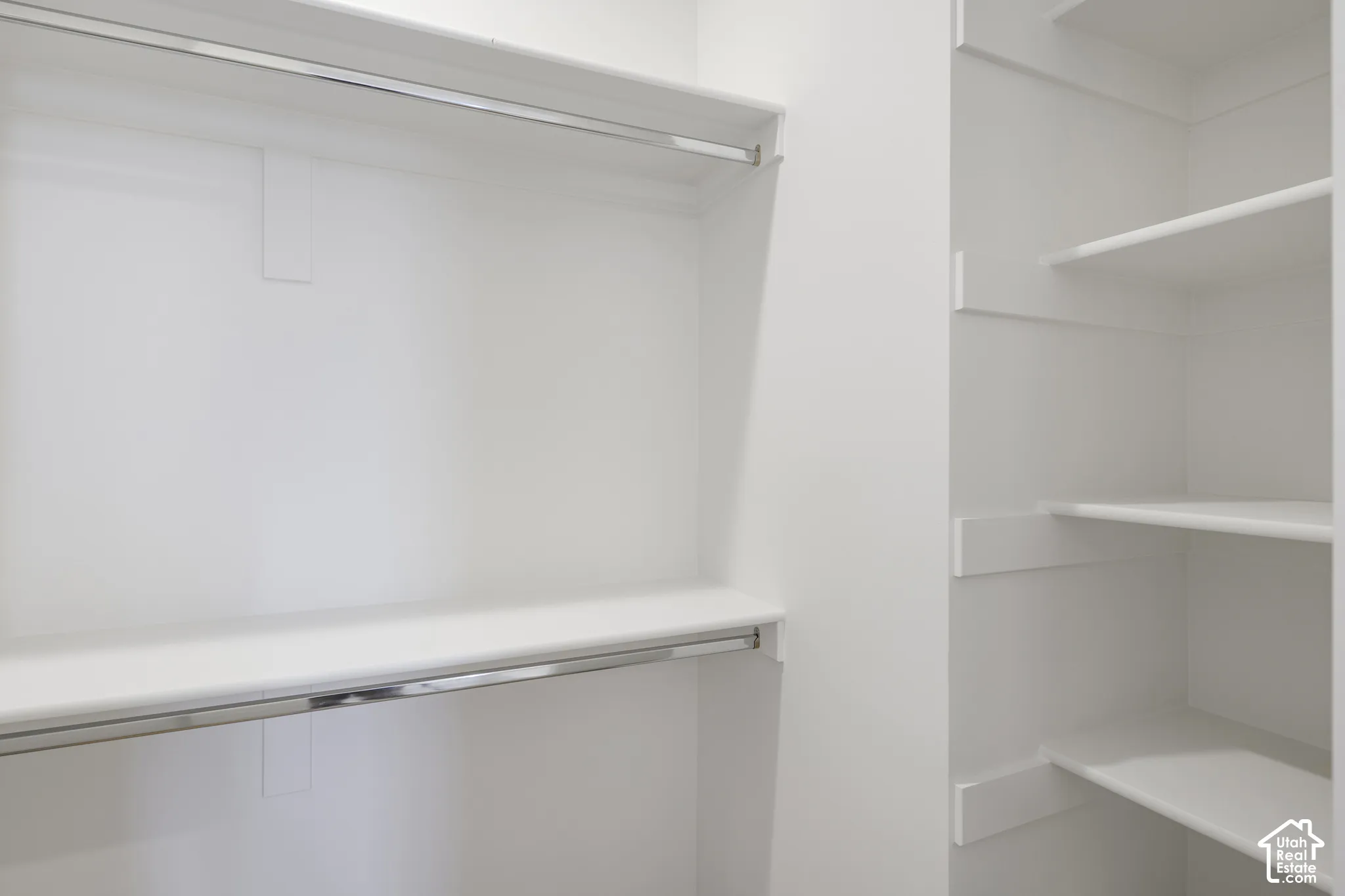 Custom storage solution featuring multi-level hanging rods and integrated fixed shelving with a white finish