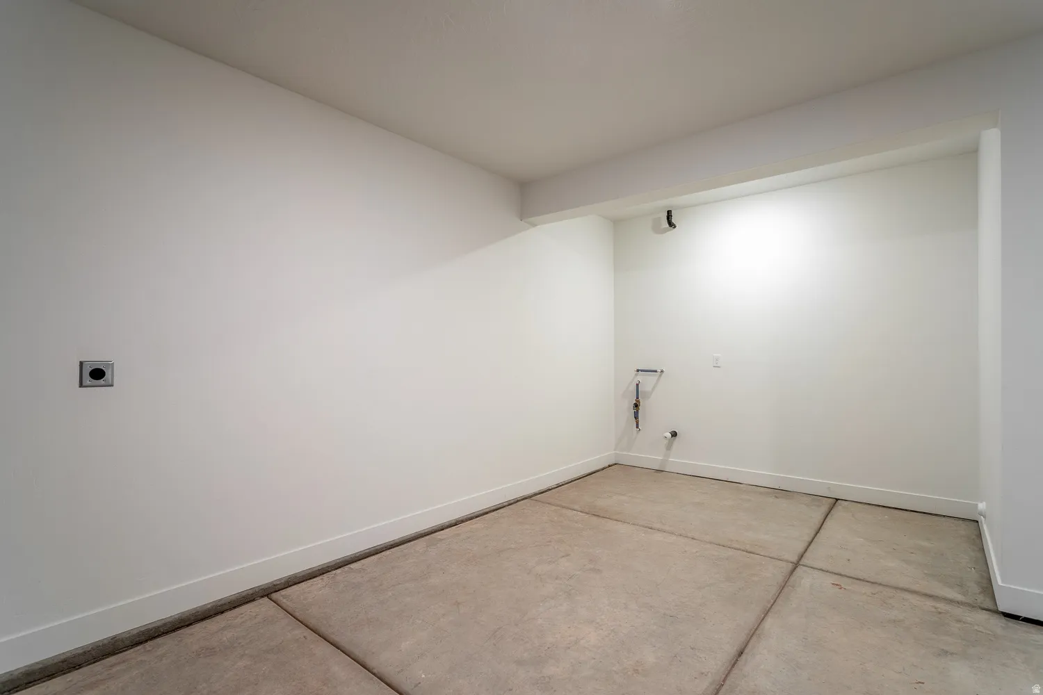 Laundry area featuring concrete flooring and hookup for an electric dryer